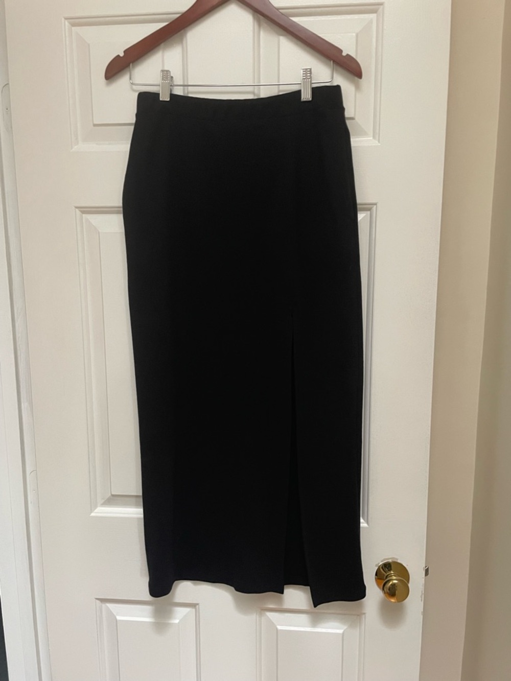 Women's Sleek Black Midi Skirt with Front Slit and Pockets.